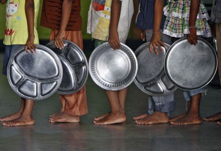 Children holding plates wait in a queue to receive food at an orphanage run by a non-governmental organisation on World Hunger Day, in the southern Indian city of Chennai