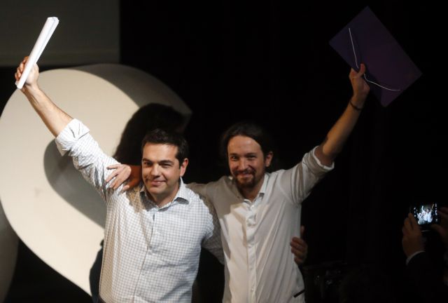 Podemos leader Pablo Iglesias stands by the side of Alexis Tsipras