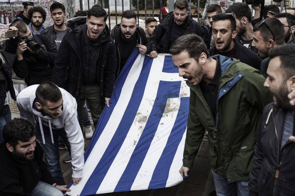 Συνθήματα για το άσυλο κατά τη μεταφορά της σημαίας του Πολυτεχνείου