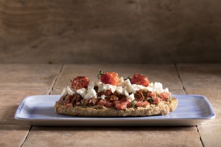 Ντάκος με ψητά ντοματίνια, λιαστή ντομάτα και ξινομυζήθρα