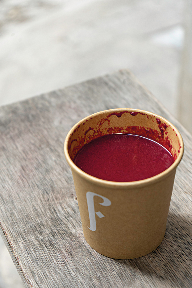 Ένα κύπελο γεμάτο με κατακόκκινη σούπα από παντζάρι, τζίντζερ, ξινόμηλο, καρότο και πορτοκάλι