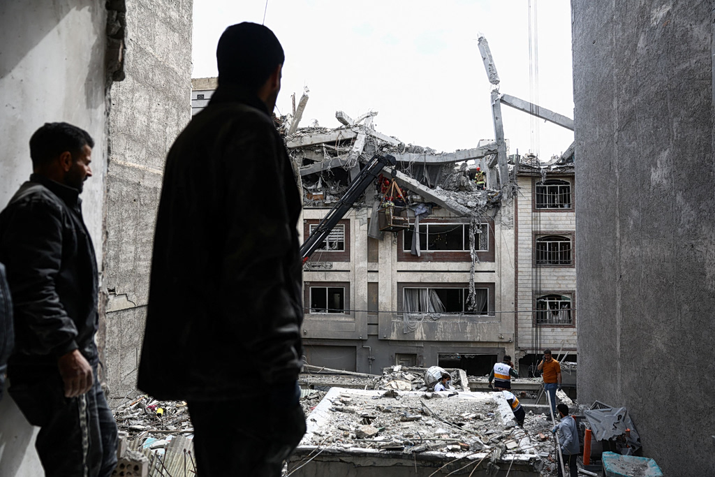 A man looks at a residential building damaged by a strike, amid the U.S.-Israeli conflict with Iran, in Tehran, Iran, March 27, 2026. Majid Asgaripour/WANA (West Asia News Agency)